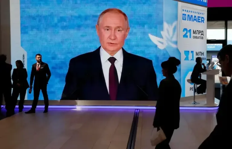 Participants walk past a large screen showing an image of Russian President Vladimir Putin during the St. Petersburg International Economic Forum (SPIEF) on June 4, 2026. (EFE/EPA/ANATOLY MALTSEV).