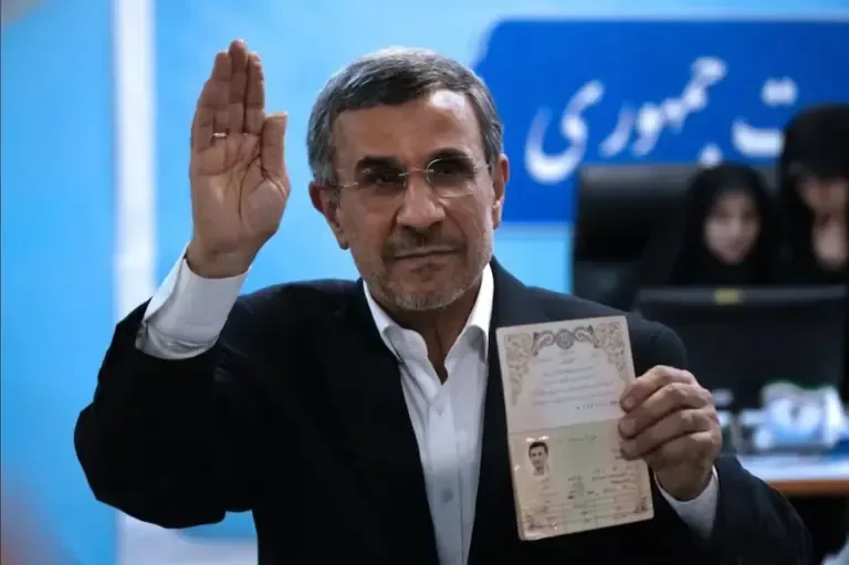 The hardline former Iranian president, Mahmoud Ahmadinejad, shows his ID to the media upon arrival at the Interior Ministry to register his presidential candidacy on June 2, 2024. (AP Photo/Vahid Salemi).