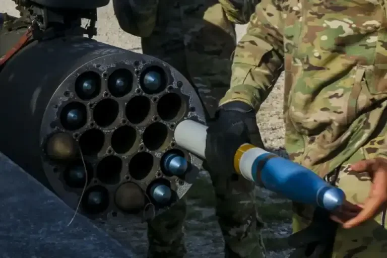 Military personnel manipulate a guided rocket in a launcher. Photo: EFE
