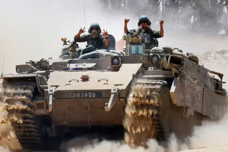 Soldados de Israel hacen un gesto desde un vehículo militar en la frontera sur con la Franja de Gaza el 20 de mayo de 2025, en medio de la guerra en curso contra el movimiento militante palestino Hamás. (Foto de Jack GUEZ / AFP).