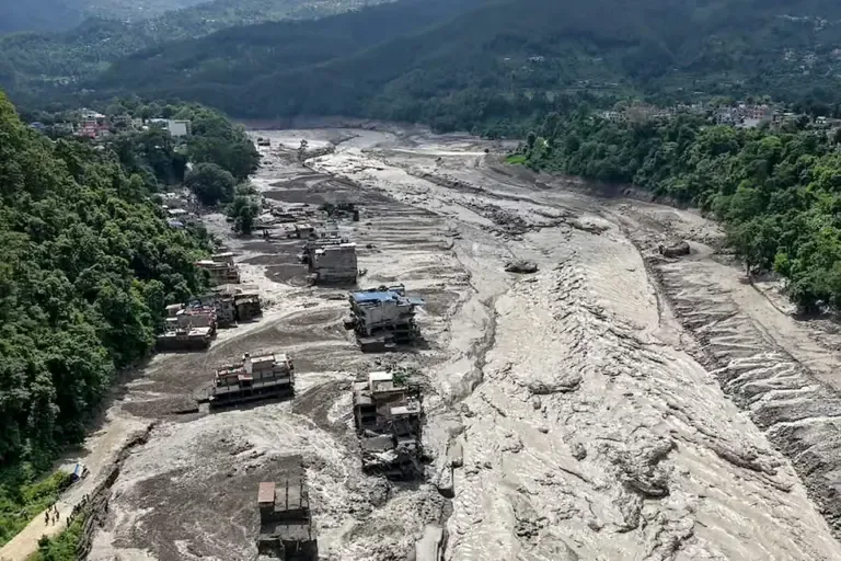 Several houses were partially submerged in muddy water on the banks of a river after sudden floods in Trishuli Bazar, Nuwakot district, Nepal, on August 26, 2026. (Photo by Prabin RANABHAT / AFP).