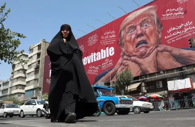 A woman walks next to an anti-Donald Trump billboard in Tehran, Iran, August 19, 2026. (EFE/EPA/ABEDIN TAHERKENAREH).