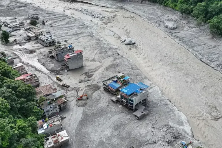 An aerial view shows houses submerged in mud after sudden floods in Trishuli, Nuwakot district, Nepal, on August 27, 2026. (Photo by Arun SANKAR / AFP).