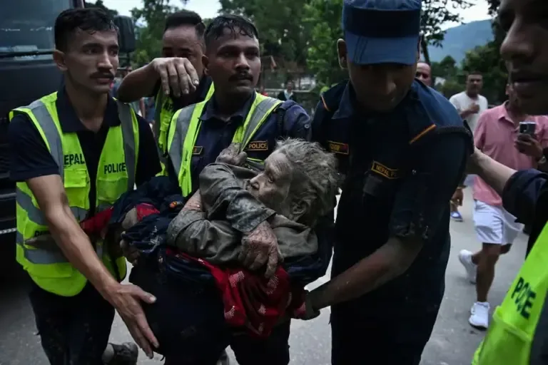 Rescuers carry a flood survivor in their arms after the sudden floods and landslide in Devghat, Nuwakot district, Nepal, on August 26, 2026. (PRAKASH MATHEMA / AFP)