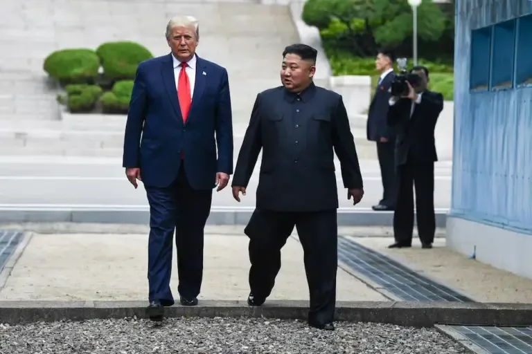 North Korean leader Kim Jong-un and U.S. President Donald Trump cross south of the Military Demarcation Line dividing North and South Korea on June 30, 2019. (Photo by Brendan Smialowski / AFP).
