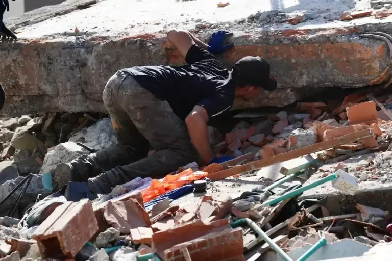 A man searches for survivors among the rubble of a collapsed building after the earthquake that shook Pereira, Colombia, on August 11, 2026. (Jaime SALDARRIAGA / AFP)