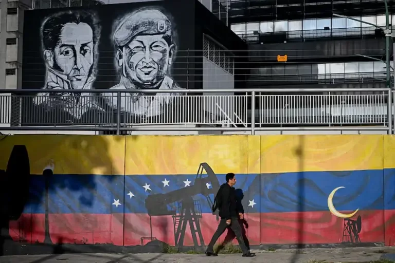 A man walks past a mural representing oil pumps and the flag of Venezuela, with portraits of Simón Bolívar (left) and Hugo Chávez, in Caracas on September 3, 2026. (Photo by Federico PARRA / AFP).